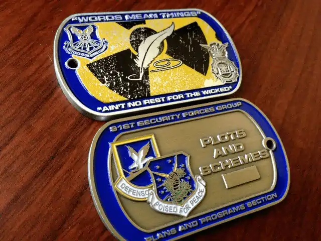 A collection of custom military-style dog tags and challenge coins