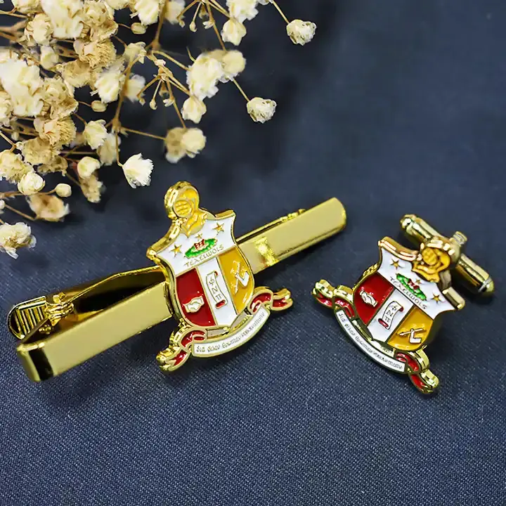 A gold crest tie clip and lapel pin set, showcasing formal accessories.