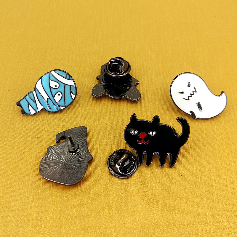 A collection of custom Halloween-themed enamel pins with various backs