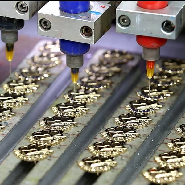 An industrial machine automatically applying color to metal components.