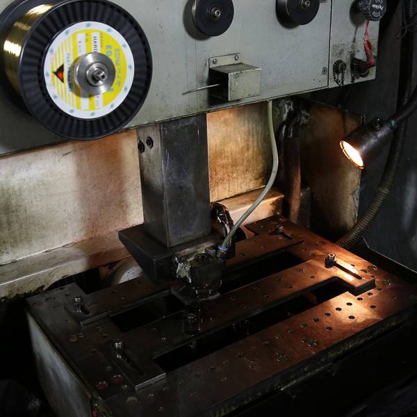 Close-up of an industrial machine's work surface during CNC outline cutting.