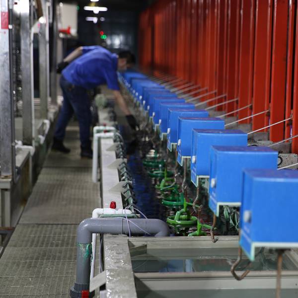 An industrial worker overseeing the electroplating equipment.