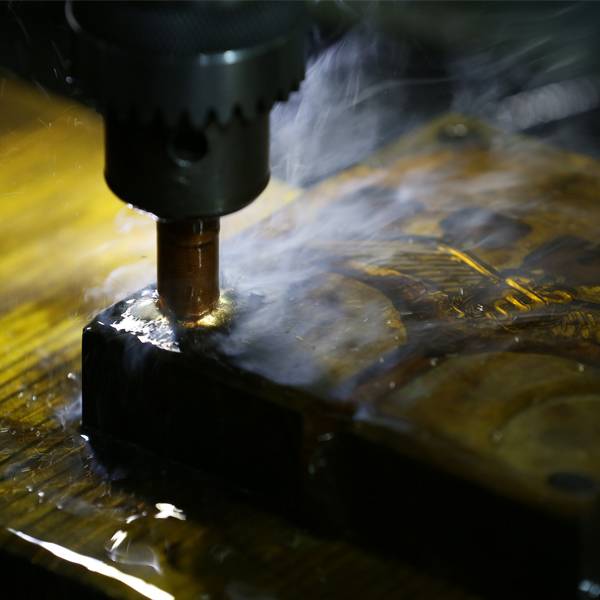 CNC EDM machining process with cooling fluid for precision mold making.